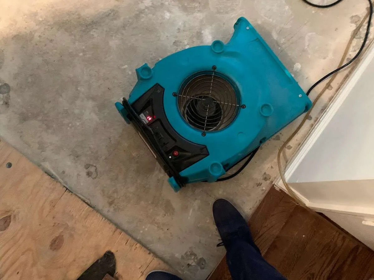 Air mover drying subfloor during Commercial Water Damage Restoration in Comstock